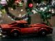 a red toy car sitting on top of a table